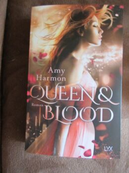 Cover des Buches „Queen and Blood“ von Amy Harmon. Eine Frau in rosa Kleid wird von roten Blüten umweht