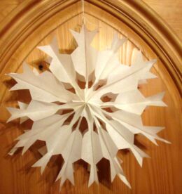 Ein Stern aus Butterbrottüten an einer braunen Holztür