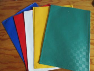 ein blauer, ein roter, ein weißer, ein gelber und ein grüner Umschlag liegen auf einem braunen Tisch