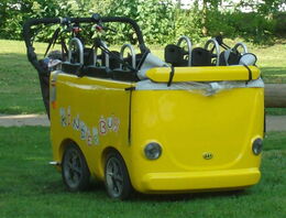 Eine Schaukel in Form eines gelben Busses auf einer Wiese