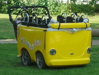 Eine Schaukel in Form eines gelben Busses auf einer Wiese
