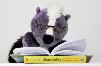 Das Plüschstinktier Teo liest in einem Kinderbuch von Corinna Wieja.